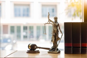 Scales of Justice and law books on desk